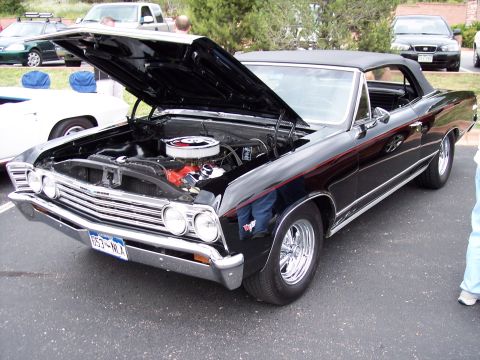 1972 Ford Ranchero - A classic black convertible is displayed with its hood open, revealing the engine bay and chrome details.