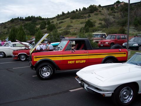 1972 Ford Ranchero - A red and yellow pickup truck with "HOT STUFF" written on the side is parked at a car show with other vehicles.