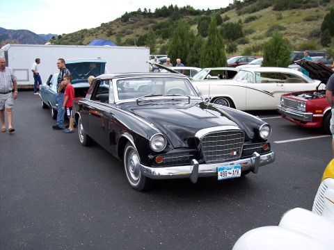 1972 Ford Ranchero - A black 1957 Studebaker Golden Hawk is parked at an outdoor car show with other vehicles.