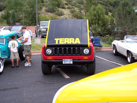 1972 Ford Ranchero - A red SUV with its hood open, displaying the word 'TERRA' in yellow letters, is parked at an outdoor event.