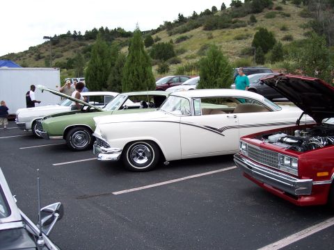 1972 Ford Ranchero - A white 1956 Ford Fairlane Crown Victoria is parked alongside other classic cars at an outdoor event.