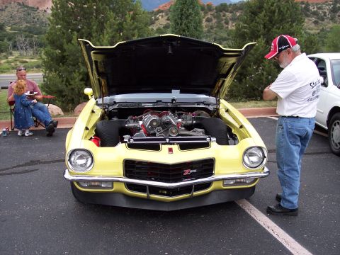 1972 Ford Ranchero - 1970 Chevrolet Camaro Z28 with a prominent supercharger, hood open, and a man examining the engine.
