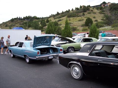 1972 Ford Ranchero - A blue 1969 Plymouth GTX coupe is parked with its trunk open, alongside other vehicles.