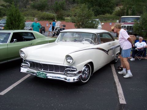 1972 Ford Ranchero - A white 1955 coupe, possibly a Ford Fairlane Crown Victoria, is displayed at a car show with onlookers.