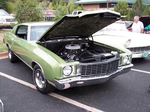 1972 Ford Ranchero - A light green 1970 Chevrolet Monte Carlo is displayed with its hood up, revealing the engine bay.