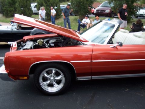 1972 Ford Ranchero - A classic orange 1972 Ford Ranchero convertible is displayed with its hood open at a car show.