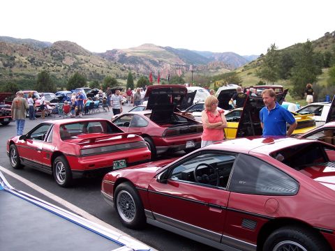 1972 Ford Ranchero - Outdoor car show multiple Pontiac Fieros with a mountainous backdrop.