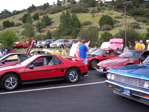 1972 Ford Ranchero - A car show scene with multiple vehicles, including a red Pontiac Fiero.