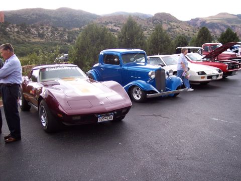 1972 Ford Ranchero - A line of classic cars are parked outdoors with mountains in the background.