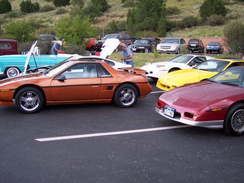 1972 Ford Ranchero - Several cars are gathered at an outdoor event, including an orange Pontiac Fiero in the foreground.