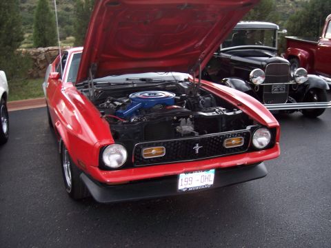 1972 Ford Ranchero - A red 1971 Ford Mustang Mach 1 is parked with its hood open, displaying its engine and front grille.