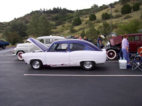1972 Ford Ranchero - A two-tone white and purple coupe with flame decals is parked at a car show with other vintage vehicles.