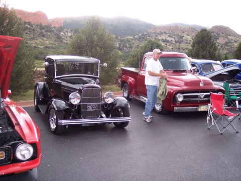 1972 Ford Ranchero - Two classic Ford vehicles, a 1955 F-100 and a 1932 coupe, are displayed at an outdoor car show.