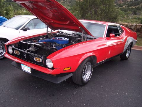1972 Ford Ranchero - A red 1971 Ford Mustang Mach 1 is parked with its hood up, revealing the engine bay.