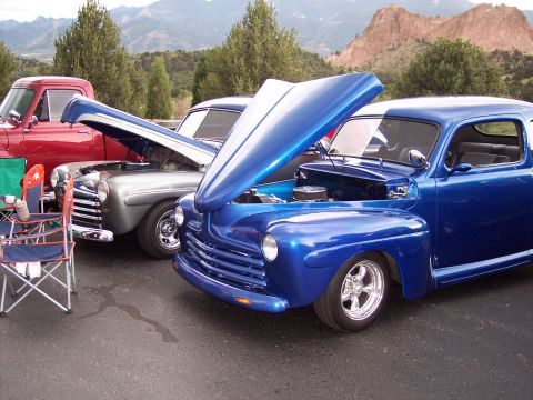 1972 Ford Ranchero - Custom blue coupe and other classic vehicles displayed outdoors with mountains in the distance.