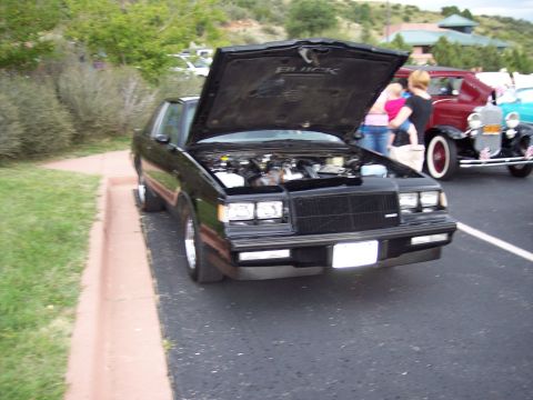 1972 Ford Ranchero - A black Buick Regal is parked with its hood open, revealing the engine compartment.