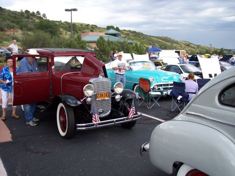 1972 Ford Ranchero - Several vintage cars are on display at an outdoor car show, with hills in the background.