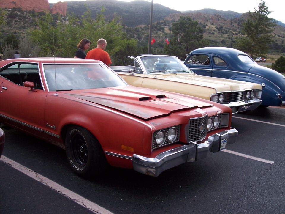 Red 1972 Ford Ranchero coupe, front quarter view, hood open, parked next to other cars