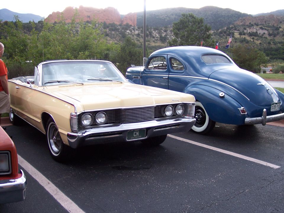 1967 Mercury Monterey convertible front view, tan color, with a blue coupe behind it