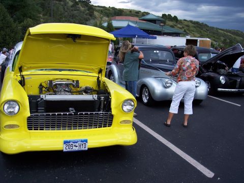 1972 Ford Ranchero - A yellow 1955 Chevrolet Bel Air is parked at a car show with other vehicles.
