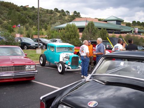 1972 Ford Ranchero - People gather around cars at an outdoor event with a building and hills in the background.