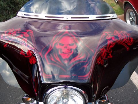 1972 Ford Ranchero - A motorcycle's front fairing features custom airbrush art of a grim reaper skull with red accents.