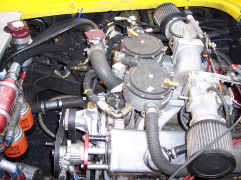1972 Ford Ranchero - Close-up view of an engine bay dual carburetors, prominent air filters, and Fram oil filters, suggesting a performance-oriented setup.