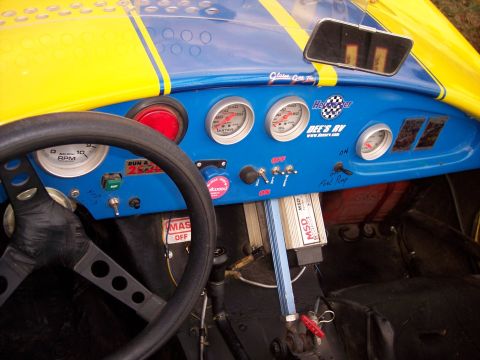 1972 Ford Ranchero - Interior view of a custom hot rod, a bright blue dashboard with yellow stripes and numerous gauges.