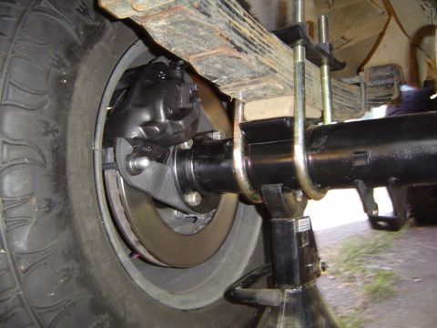 1978 Ford Bronco - The rear axle and brake components are visible, supported by a jack stand during maintenance.