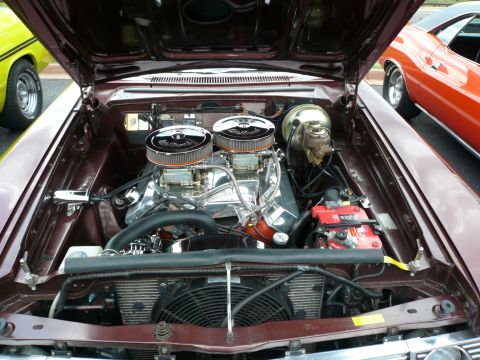 1975 Ford Ranchero - A highly customized V8 engine with dual carburetors is displayed with other vehicles nearby.