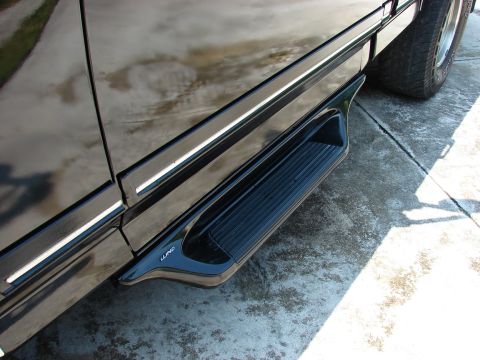 1987 Ford F-150 - Close-up of a black truck's side step, the LUND brand name.
