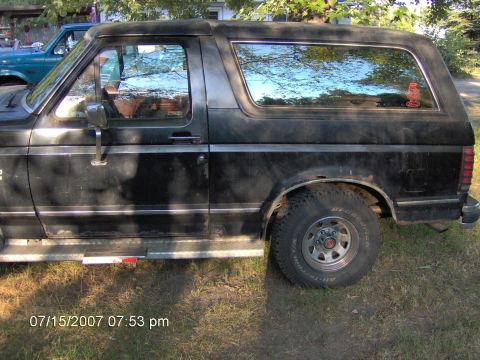 1987 Ford Bronco - This 1987 Ford Bronco is shown from the side, its black paint and chrome accents.