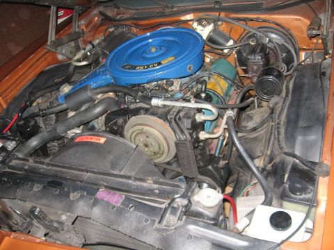 1975 Ford Ranchero - Engine bay view of a 1975 Ford Ranchero, its V8 engine and orange exterior paint.