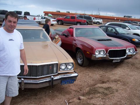 1972 Ford Ranchero - A 1972 Ford Ranchero is parked in front of another vehicle, displaying its distinctive grille and hood stripe.