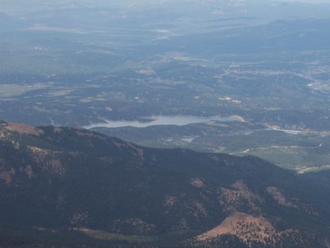 1972 Ford Ranchero - A wide aerial view captures a mountain landscape, a tranquil lake and a distant town among rolling hills.