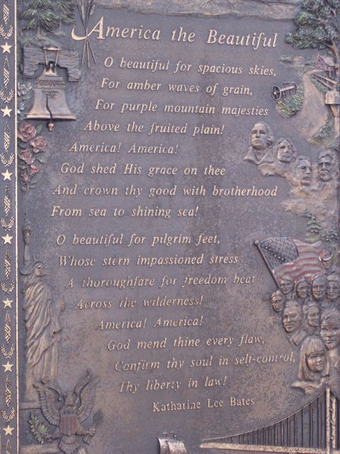 1972 Ford Ranchero - A bronze plaque displays the lyrics to 'America the Beautiful' alongside patriotic imagery and historical relief sculptures.