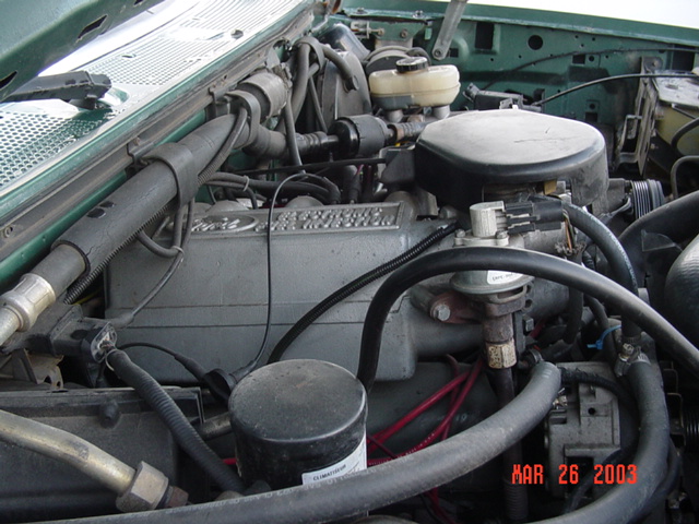 Ford truck engine bay with grey Ford intake plenum, air cleaner and brake master cylinder