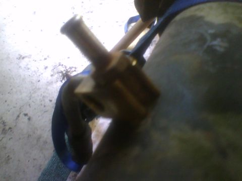 1993 Ford Bronco - A close-up view of a brass fitting secured by a blue strap.