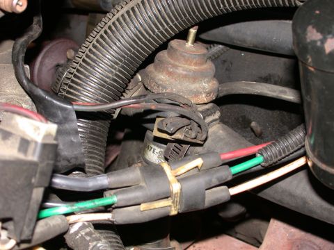 1987 Lincoln Town Car - Close-up of an engine vacuum actuator, showing electrical connectors and hoses.