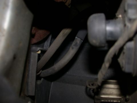 1987 Lincoln Town Car - A close-up view of various hoses and wiring harnesses within a vehicle's engine compartment.