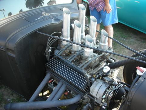 1998 Ford Crown Victoria - black hot rod's exposed V8 fitted with multi-carb induction and tall polished velocity stacks rising from the engine.