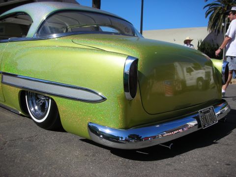 1998 Ford Crown Victoria - Rear three-quarter view of a slammed green metalflake 1950s custom coupe with chrome bumper and a California license plate.