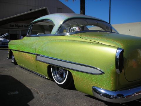 1998 Ford Crown Victoria - Side profile of a chopped, lowered 1950s custom coupe finished in green metalflake paint with chrome trim and whitewall tires.