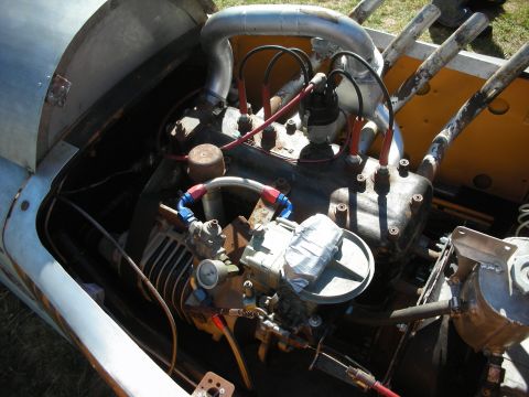 1998 Ford Crown Victoria - Engine bay of a vintage racer showing a flathead-style V8 with stacked velocity intakes, red plug wires and braided lines.