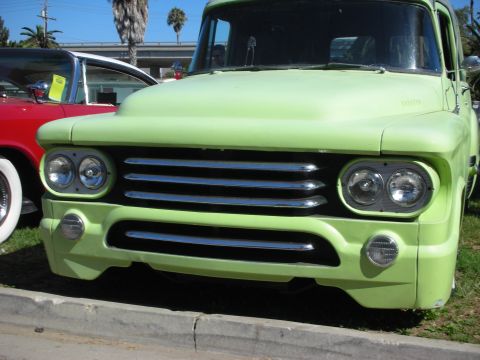 1998 Ford Crown Victoria - Detail of a lime green vintage pickup's chrome horizontal-bar grille, quad round headlights and round turn signals.