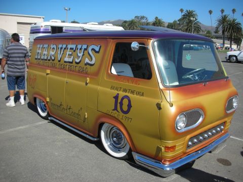 1998 Ford Crown Victoria - lowered gold-to-orange flamed custom van lettered HARVEYS with a number 10 sits on chrome wheels in a parking lot.