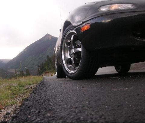 1996 Mazda Miata - Low angle shot of a 1996 Mazda Miata's front corner on a winding mountain road.