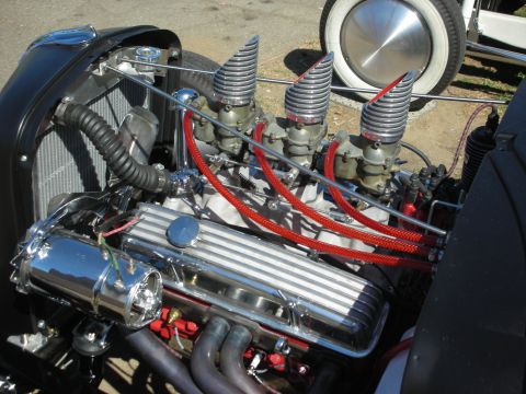 1998 Ford Crown Victoria - polished hot rod V8 engine fitted with multiple chrome carburetors topped by velocity stacks and red spark plug wires.