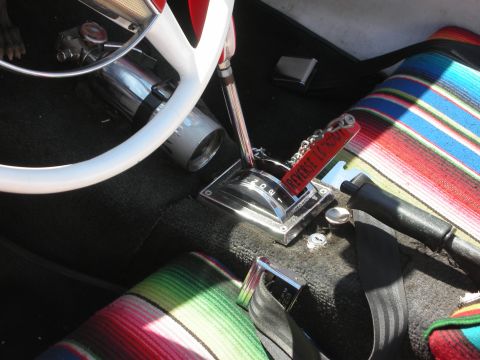 1998 Ford Crown Victoria - hot rod cabin with a white steering wheel, chrome floor shifter and colorful serape-covered seats over black carpet.