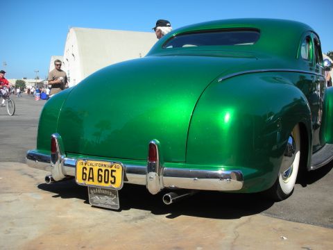 1998 Ford Crown Victoria - Rear quarter of a glossy metallic green custom coupe with whitewall tires and a 1940 California plate reading 6A605.